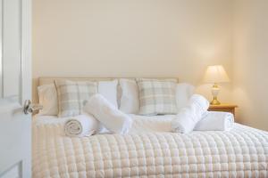 a white bed with towels and pillows on it at Cottage 8 Old Farmhouse braithwaite in Keswick