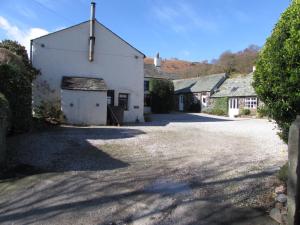 a large white building with a garage in a driveway at Cottage 8 Old Farmhouse braithwaite in Keswick