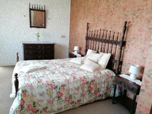 a bedroom with a large bed with a floral bedspread at CLE House in Anadia