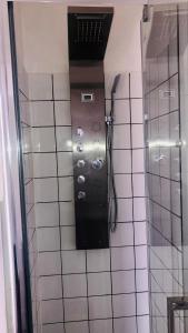 a shower in a bathroom with a tile wall at Super location 2, 1min metro 10 min from Camden in London