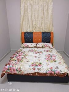 Una cama con un cabecero naranja con flores. en Ain Homestay, en Kuala Terengganu