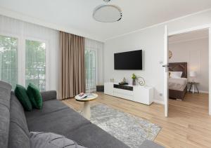salon z kanapą i telewizorem w obiekcie Baltic Residence Apartamenty Alkam apartament nr 7, 8 - Klimatyzowany, Warszawska 11 w Pobierowie