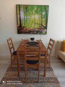 une table à manger avec des chaises et un tableau mural dans l'établissement Berghof Studio Haus Rachel, à Sankt Englmar