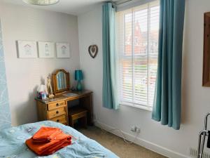 a bedroom with a bed and a mirror and a window at Arden Holiday Lettings in Stratford-upon-Avon