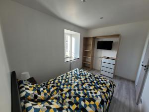 1 dormitorio con 1 cama y TV en Aux portes du Mont, en Saint-James