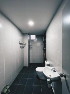 ein Badezimmer mit einem weißen Waschbecken und einem WC in der Unterkunft Hikaru Homestay Ladang Tanjung, Kuala Terengganu with POOL in Kuala Terengganu