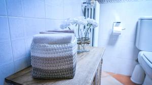 une salle de bain avec une table avec des serviettes et des fleurs dessus dans l'établissement NEW! Suite Apartment, à Castelnuovo del Garda