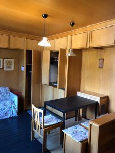 a dining room with a table and chairs and a bed at Appartamento per max 6 pers nel centro di San Martino di Castrozza n 31 in San Martino di Castrozza
