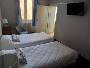 Postel nebo postele na pokoji v ubytování Hôtel des Cymaises