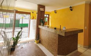 uma casa de banho com um balcão e uma parede amarela em RioSlz Hostel em São Luís