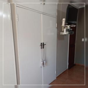 a white cabinet with a tv and a mirror at A-Cody Place in Louis Trichardt