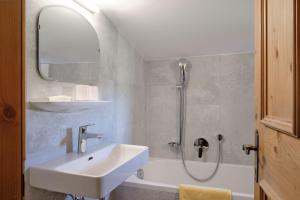 bagno bianco con lavandino e doccia di Pension Landhaus Gasteiger a Kitzbühel Altre 37 foto