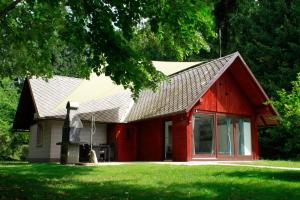 una casa roja con techo de gambrel en Čebelnk: sanjska hišica 4 km od Bleda en Lesce