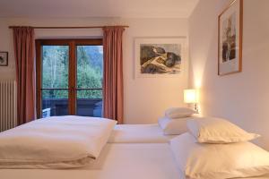 two beds in a hotel room with a window at Pension Landhaus Gasteiger in Kitzbühel