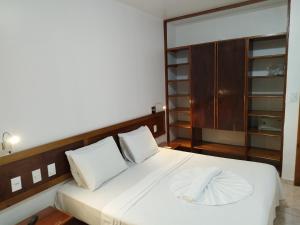 a bedroom with a large white bed with white pillows at Apart Boulevard da Praia 155D in Porto Seguro