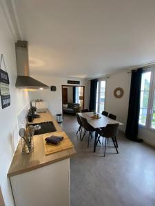 cocina y sala de estar con mesa y comedor en Studio +++ très agréable en centre ville, en Doué-la-Fontaine