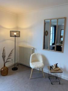 - un salon avec une chaise et un miroir dans l'établissement Studio +++ très agréable en centre ville, à Doué-la-Fontaine