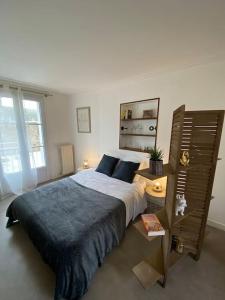 um quarto com uma cama grande e uma janela grande em Studio +++ très agréable en centre ville em Doué-la-Fontaine
