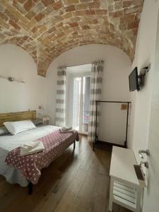 um quarto com uma cama e um tecto em tijolo em Il Torrione em Tarquinia