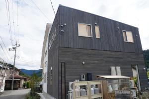 a black building with windows on the side of it at SORAYADO 宙宿 in Tsuru 