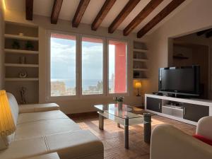 een woonkamer met een bank en een tv bij Villa Manzanera in Calpe