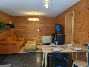 a living room with a table and a couch at LES ACACIAS in Moye +20 photos