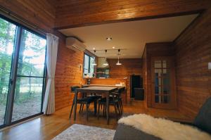 comedor y cocina con mesa y sillas en HARUNA WING Private cottage in the forest overlooking the golf course en Azumaiokozan