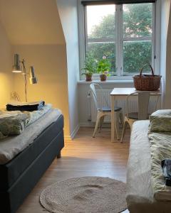 uma sala de estar com um sofá, uma mesa e uma janela em Room 15 - Hawkraft kulturhotel em Vestervig