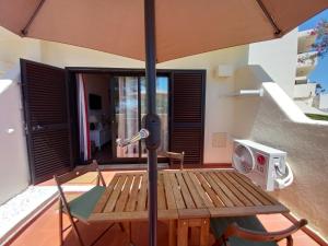 uma mesa de piquenique com um guarda-chuva no pátio em Casa da Carmen - Estúdio em Albufeira em Albufeira