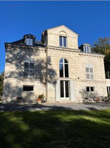 ein großes Steinhaus mit einem großen Fenster in der Unterkunft Domaine de Bonneuil in Bonneuil-les-Eaux