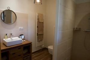 a bathroom with a sink and a toilet and a mirror at Aux 3 Forêts in Bizeneuille
