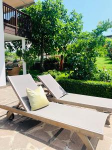 two lounge chairs with a yellow pillow on a patio at Weingut Weidlhof - Suite & Breakfast - Vacation for wine lovers in Caldaro