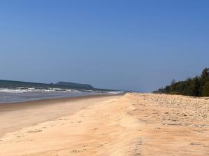 a sandy beach with footprints in the sand at Atlantis Beach Resorts in Kumta