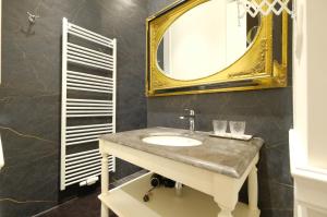 een badkamer met een wastafel en een spiegel bij Suite la Duchesse et Parking privé gratuit in Bergen