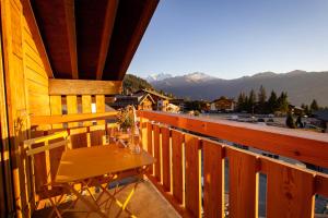 una mesa en un balcón con vistas a las montañas en Shed HOTEL en Verbier