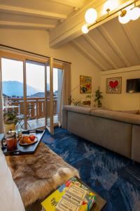 ein Zimmer mit Sofa und Tisch mit Essen drauf in der Unterkunft Shed HOTEL in Verbier