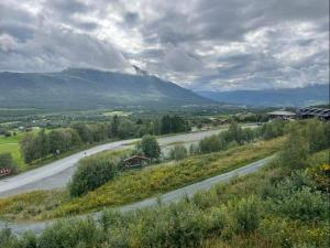 a winding road with a mountain in the background at Flott leilighet med ski in ski out, utsikt og balkong in Oppdal