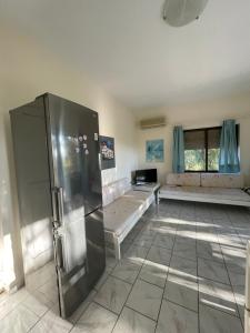 a large room with a refrigerator and two beds at Tersanas Beach Apartments in Chorafakia