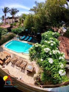 uma vista superior de uma piscina com cadeiras e flores em Pousada Casa Do Angelo em Jericoacoara