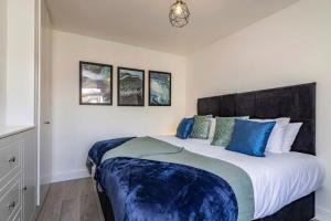 una camera da letto con un grande letto con cuscini blu di Westfield 3 Bed Characterful and Modern House FREE PARKING and private garden a Mansfield