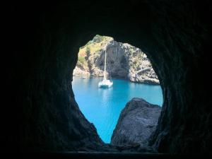 un barco en el agua a través de una cueva en SO Ionian Getaways, en Agios Gordios