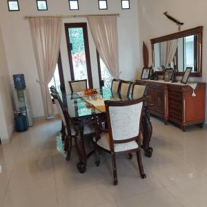 a dining room with a table and chairs and a mirror at Villa D3 Bukit Cijulang in Bogor