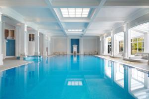 a large swimming pool with blue water in a building at Champneys Henlow in Henlow