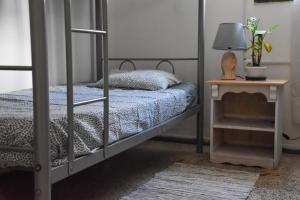 a bedroom with a bunk bed and a table with a lamp at Single Fin Hostel in Arona