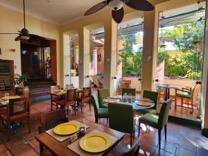 a restaurant with wooden tables and chairs and windows at Hotel Casa do Amarelindo in Salvador