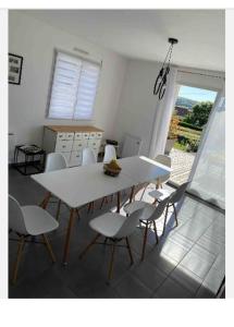 ein Esszimmer mit einem weißen Tisch und Stühlen in der Unterkunft Les coteaux vue mer in Criel-sur-Mer