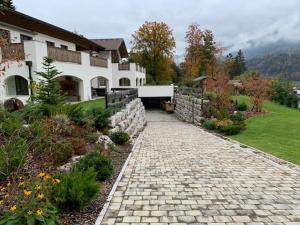a house with a stone path in front of a yard at Alpenvilla Berchtesgaden Appartements in Berchtesgaden