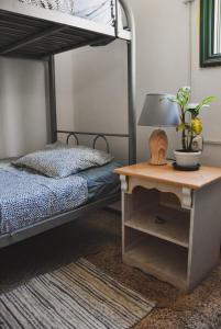 a bedroom with a bunk bed and a table with a lamp at Single Fin Hostel in Arona