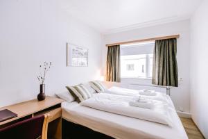 a bedroom with a bed and a desk and a window at Eldá Guesthouse in Myvatn