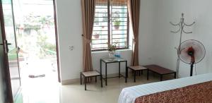 1 dormitorio con cama, mesa y ventana en Tre Xanh Homestay en Ninh Binh